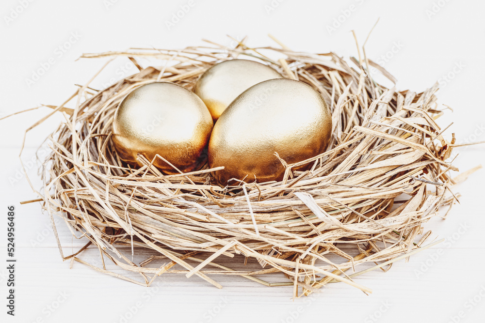 Three golden eggs in the nest on white background, copy space Three golden eggs in the nest on white background, copy space