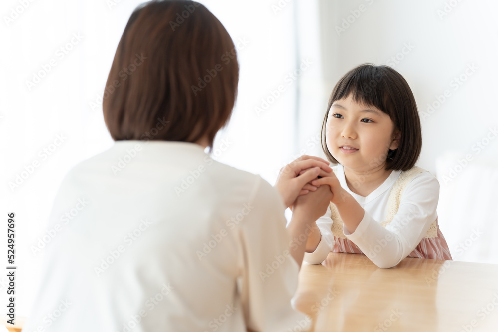 娘の手を握るお母さん