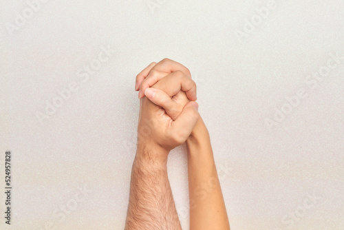 man and woman hands holding each other with fingers intertwined on glitter white background