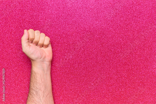 man fist on glitter pink background claiming equality