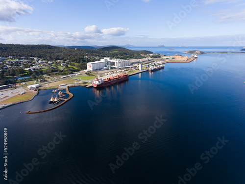 Bulk grain carrier berthed at Albany port with grain silos and tug boats photo