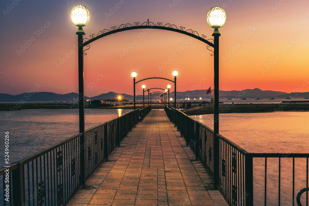A romantic bridge leading to the island at sunset. Idea concept for a beach walk