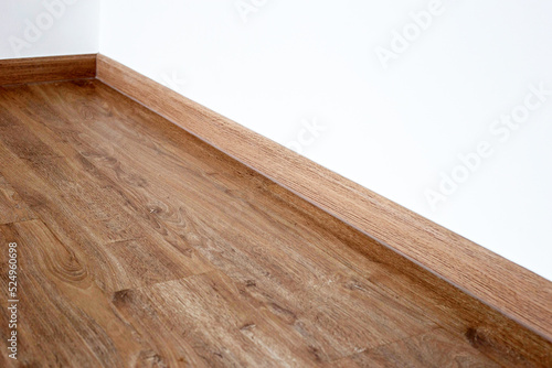 Laminate wood floor with blank white wall © Bowonpat