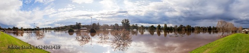 Park sports playing fields covered with floodwater seen from levee bank