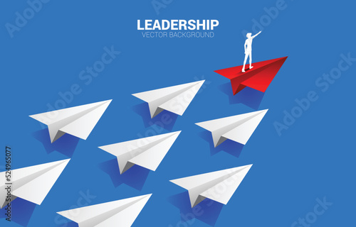 Silhouette of businessman point finger on origami paper airplane. Business Concept of leadership and vision mission.