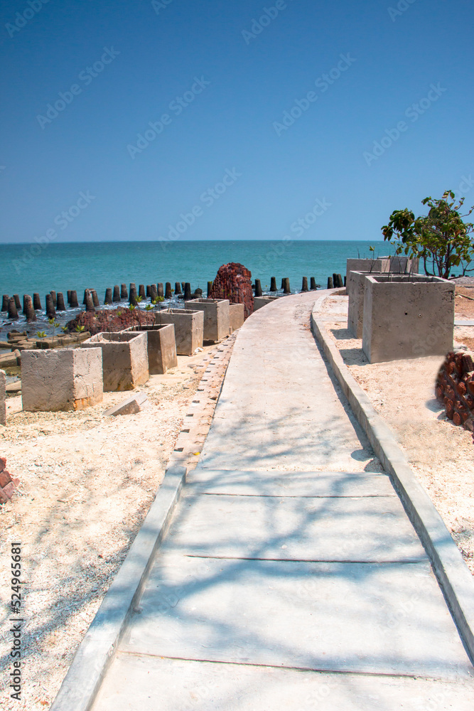 A calming cement pathway at Onrust Island, Thousand Island, Jakarta with blue clear sky and sea background