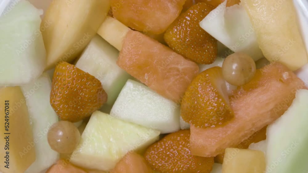 Fruit salad is rotating in a bowl. Close-up shot. Slow motion. Fruit salad is rotating in a bowl. Close-up shot. Slow motion.