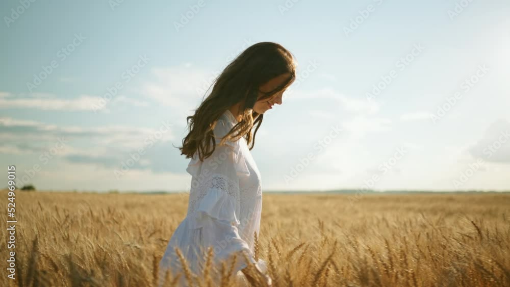 carefree woman is smiling and walking alone in golden wheat fields in summer, slow motion portrait carefree woman is smiling and walking alone in golden wheat fields in summer, slow motion portrait