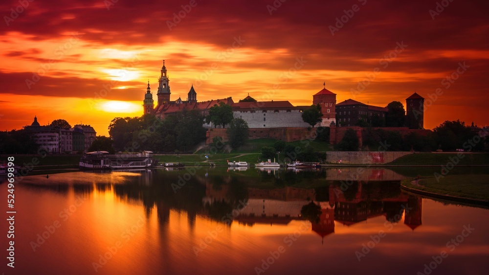 Zamek Królewski na Wawelu o wschodzie słońca ze złotym niebem w tle