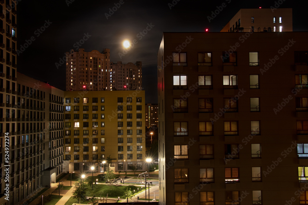 Night city landscape. Residential area in summer twilight. Dense urban development. Aerial view.