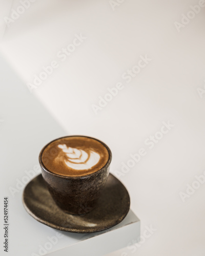 cup of coffee with latte art on white table.