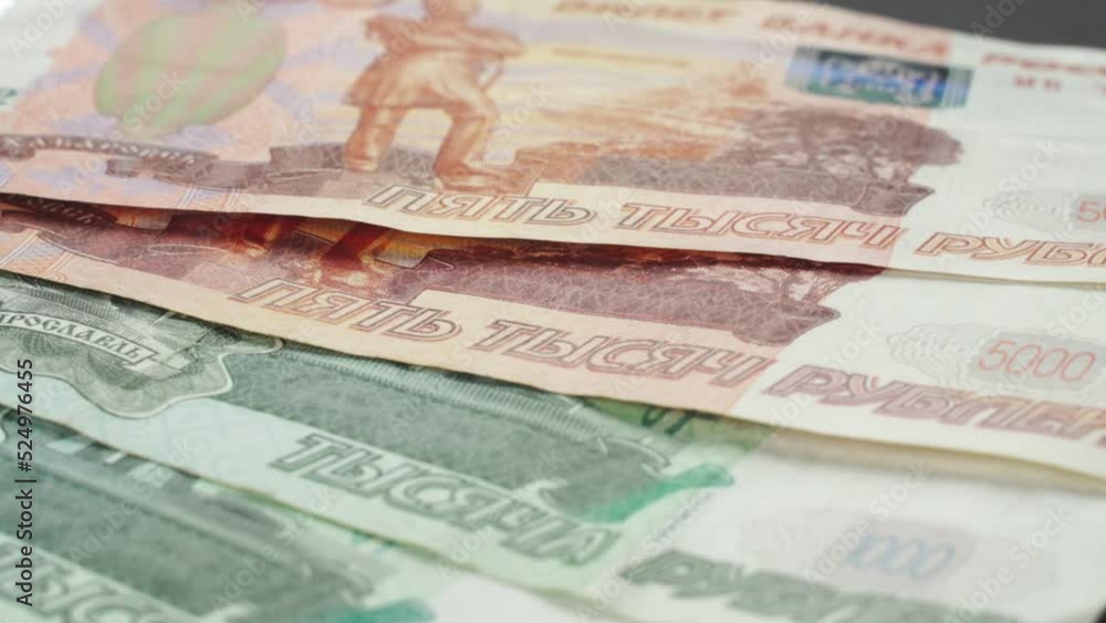 Banknotes in denominations of 1000 and 5000 Russian rubles lie on a platform rotating clockwise. Close-up Banknotes in denominations of 1000 and 5000 Russian rubles lie on a platform rotating clockwise. Close-up