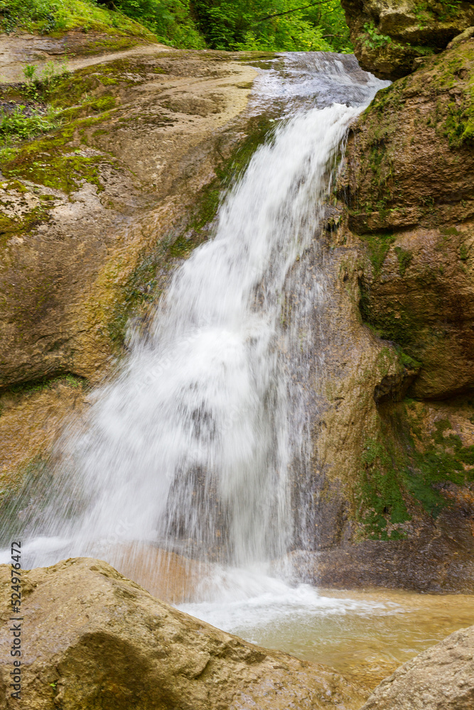 A mountain river in a natural channel with rapids and waterfalls in the bosom of nature. A mountain river in a natural channel with rapids and waterfalls in the bosom of nature.