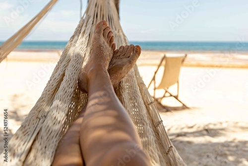 Fototapeta Naklejka Na Ścianę i Meble -  Woman's legs in the hammock against the ocean view