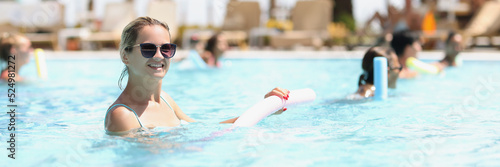 Beautiful woman with healthy body and vitality enjoys summer day in pool