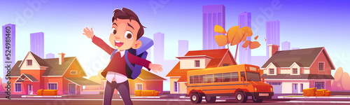 Happy boy waiting school bus in city suburb. Cartoon illustration of kid with backpack smiling, standing at transport stop, town street with many houses, yellow vehicle taking children to classes