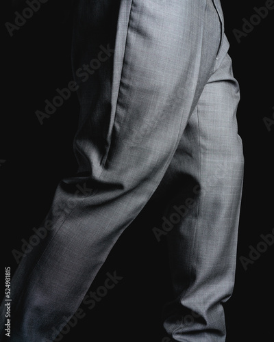Gray pants on a black background. Fine fabric texture. Elegant suit pants. High quality photo © Wacha Studio