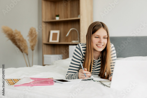 Portrait of a cute girl student preparing for lectures using a laptop. The concept of training and education, modern technologies