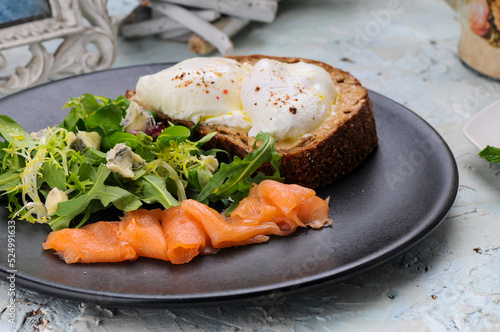 bruschetta with a poached egg in a plate with salmon and greens
