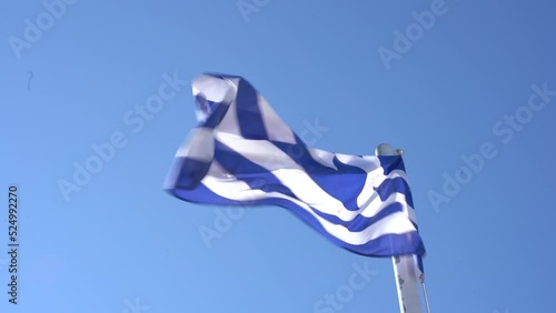 A greek flag waving in the harbor of Skiathos photo