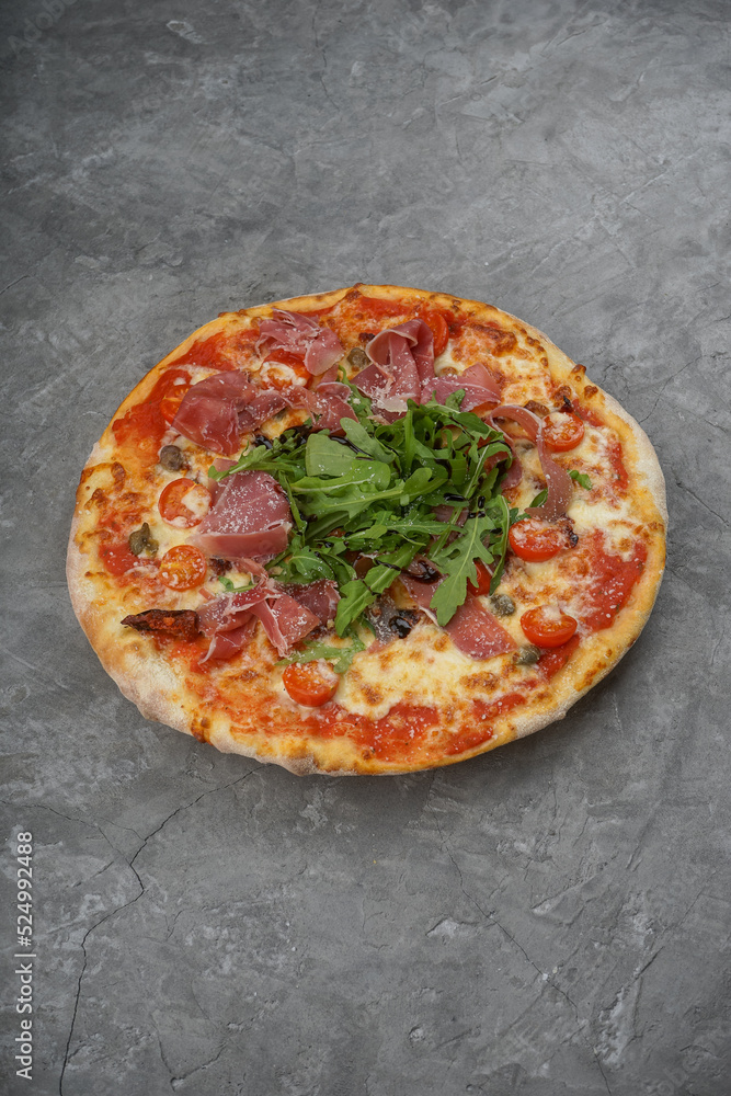 pizza with bacon and arugula on a gray background, vertical photo

