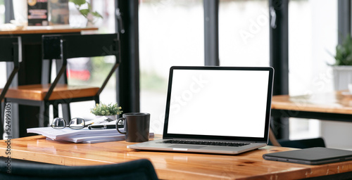 Creative workspace, blank screen laptop computer on wooden table, mockup blank screen laptop. © NAMPIX