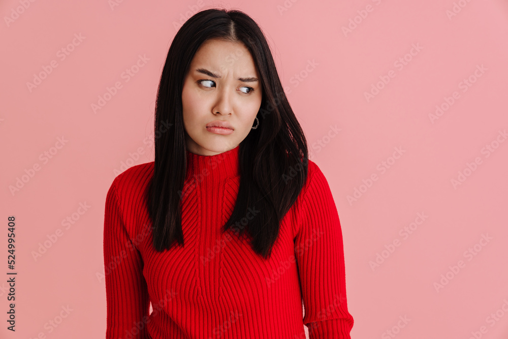Asian displeased woman frowning and looking aside Asian displeased woman frowning and looking aside