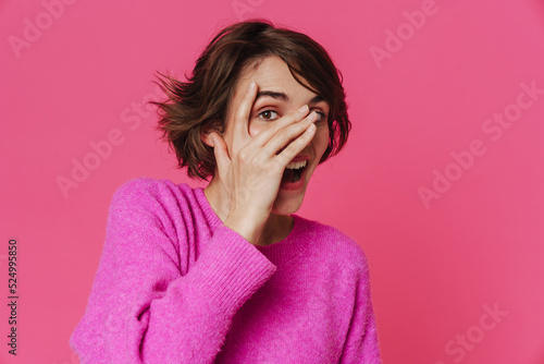 White young woman wearing sweater laughing while covering her face © Drobot Dean