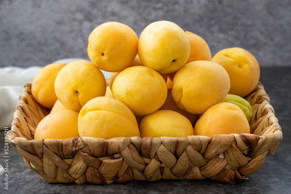 Ripe apricots on a dark background. Fresh and juicy apricots in the basket. Organic food. close up