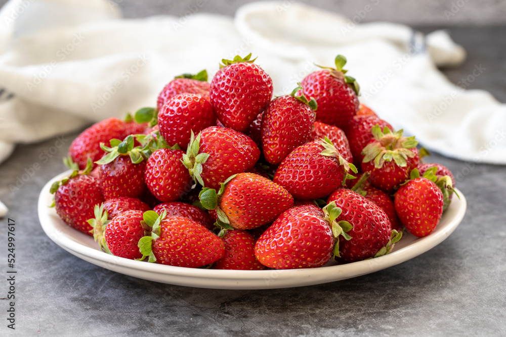 Ripe strawberries on a dark background. Fresh strawberries on the plate. Organic food. close up Ripe strawberries on a dark background. Fresh strawberries on the plate. Organic food. close up