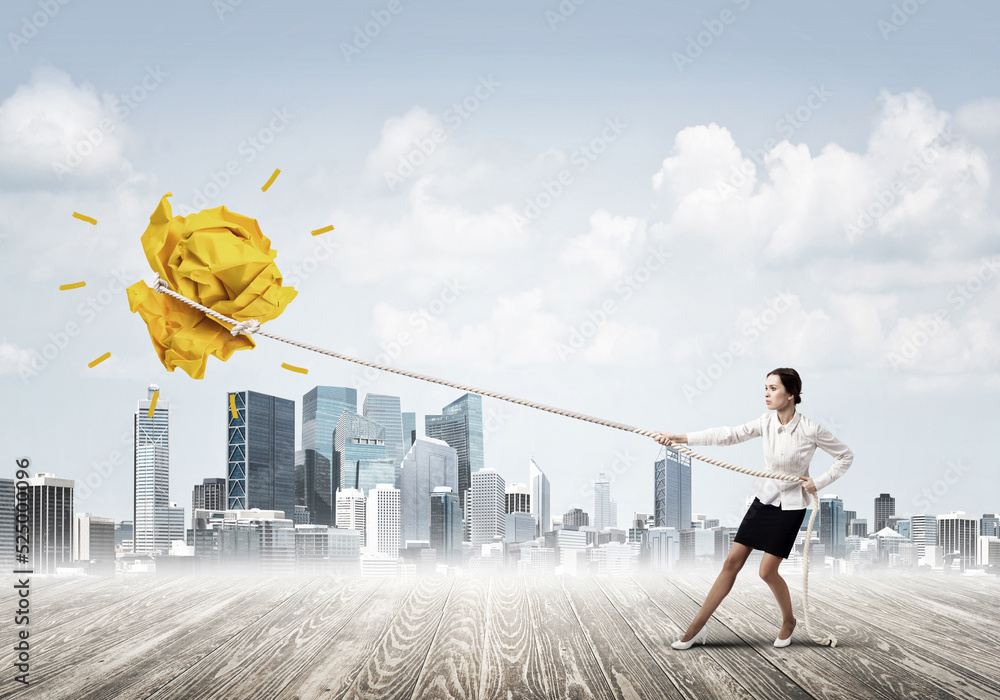 Businesswoman pulling paper ball with rope and making it raise up
