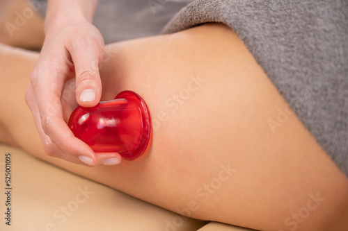 Woman on a session of anti-cellulite massage with a vacuum jar. 