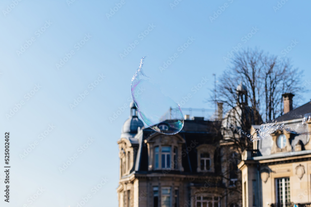 Fototapeta premium Iridescent soap bubble bursting on luxury real estate property background