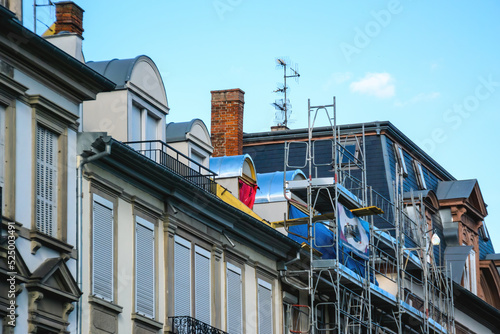 Scaffolding on the rooftop of a french mansard building repair of the roof after hurricane isolation of the facade