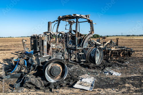 Feux de champs, carcasse de tracteur et d'un déchaumeur calciné suite à un incendie de chaumes lors de forte canicule photo