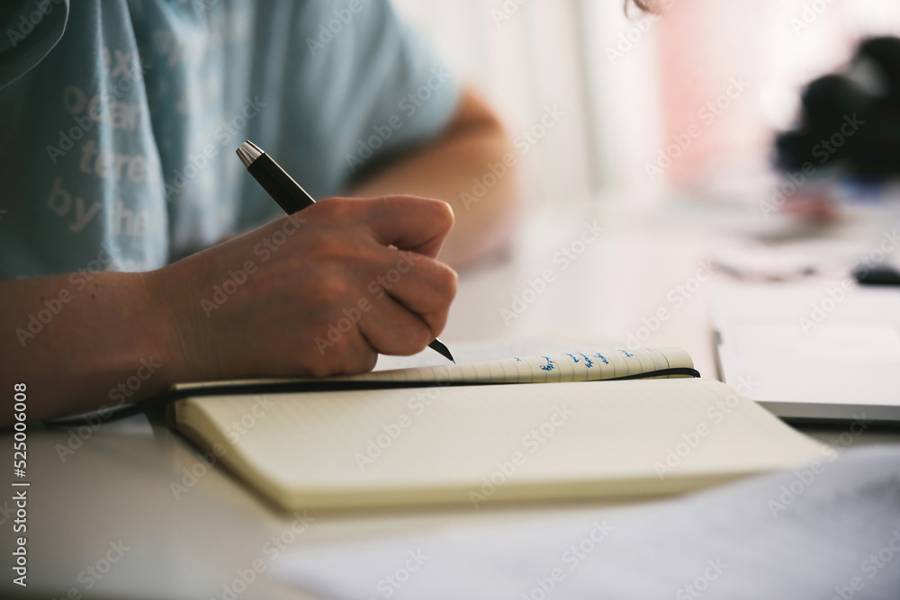 Side view of woman using fountain pen to write in her diary taking notes writing a poem - shallow depth of field Side view of woman using fountain pen to write in her diary taking notes writing a poem - shallow depth of field