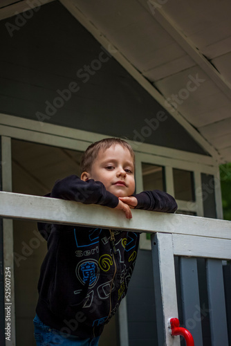 A child is playing on the playground in a children's house. Presents himself as the owner of the house. Portrait of a child