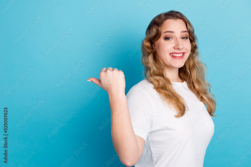 Fototapeta premium Photo of charming young woman dressed shirt smiling pointing finger empty space isolated blue color background