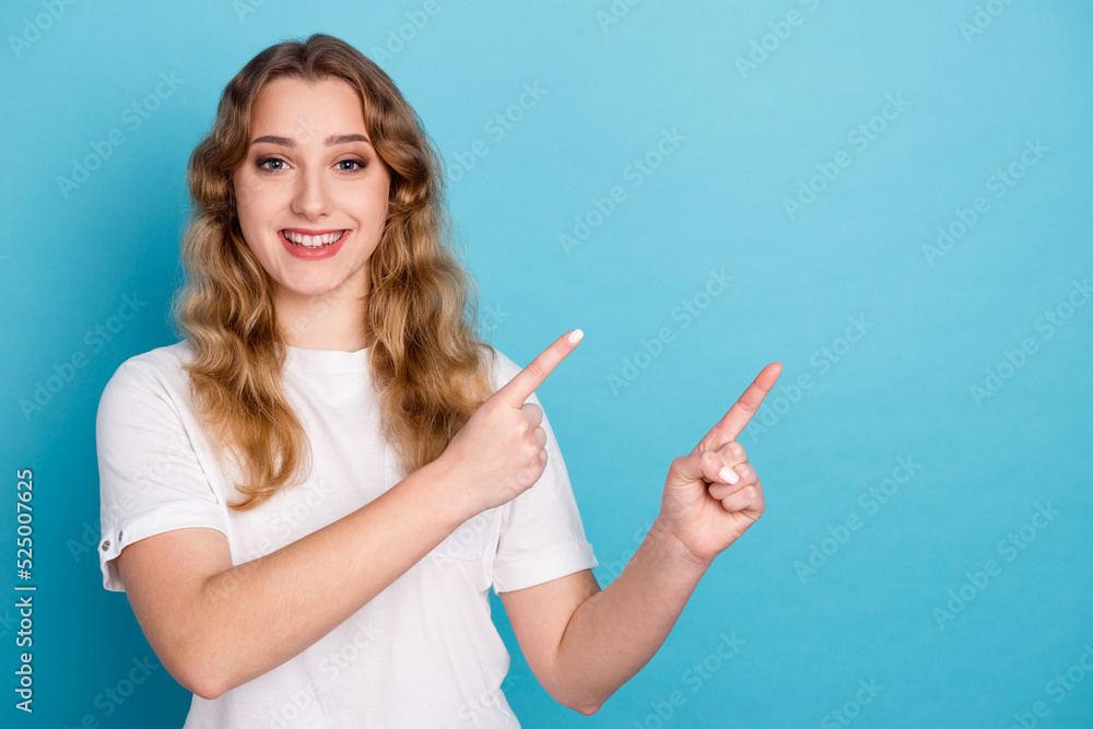 Photo of charming young woman dressed shirt smiling pointing finger empty space isolated blue color background