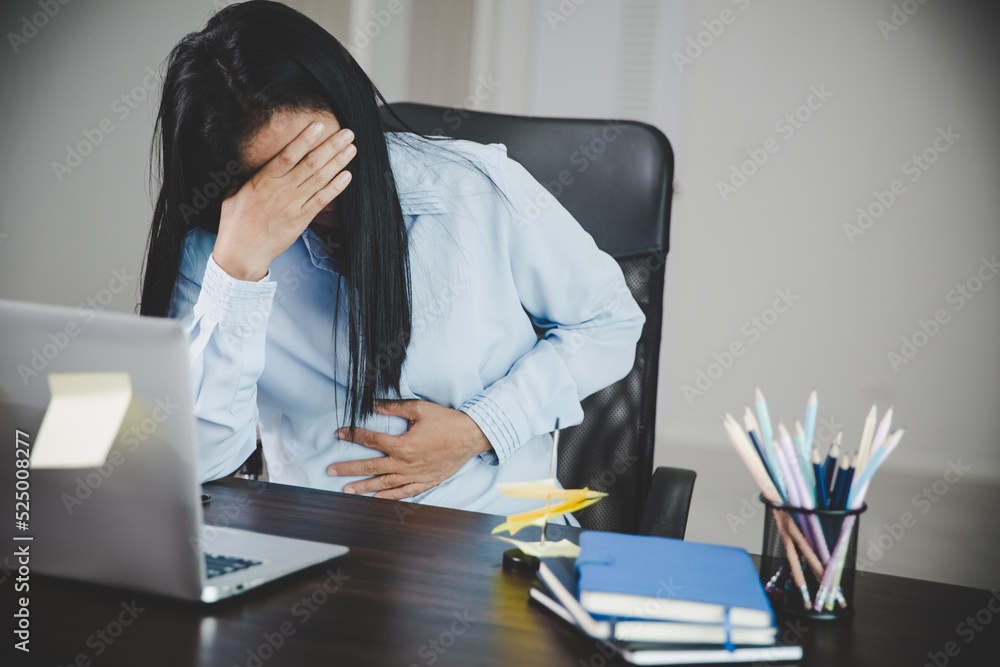 Young asian business woman person sitting at work and has stress pain in her stomach. Concept office syndrome abdomen pain from occupational disease, Female having belly pain and using laptop computer Young asian business woman person sitting at work and has stress pain in her stomach. Concept office syndrome abdomen pain from occupational disease, Female having belly pain and using laptop computer