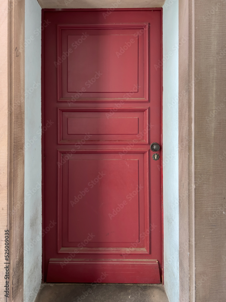 Majestic cleanly painted red door with black steel door handle