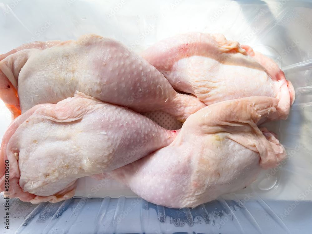 Close-up of plastic package with four organic bio raw chicken legs Close-up of plastic package with four organic bio raw chicken legs