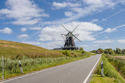 Germany, Schleswig-Holstein, Pellworm, Country road with Nordermuhle mill in background photo