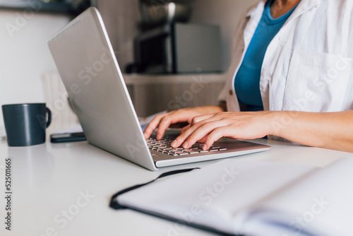 Hands of businesswoman typing on laptop photo