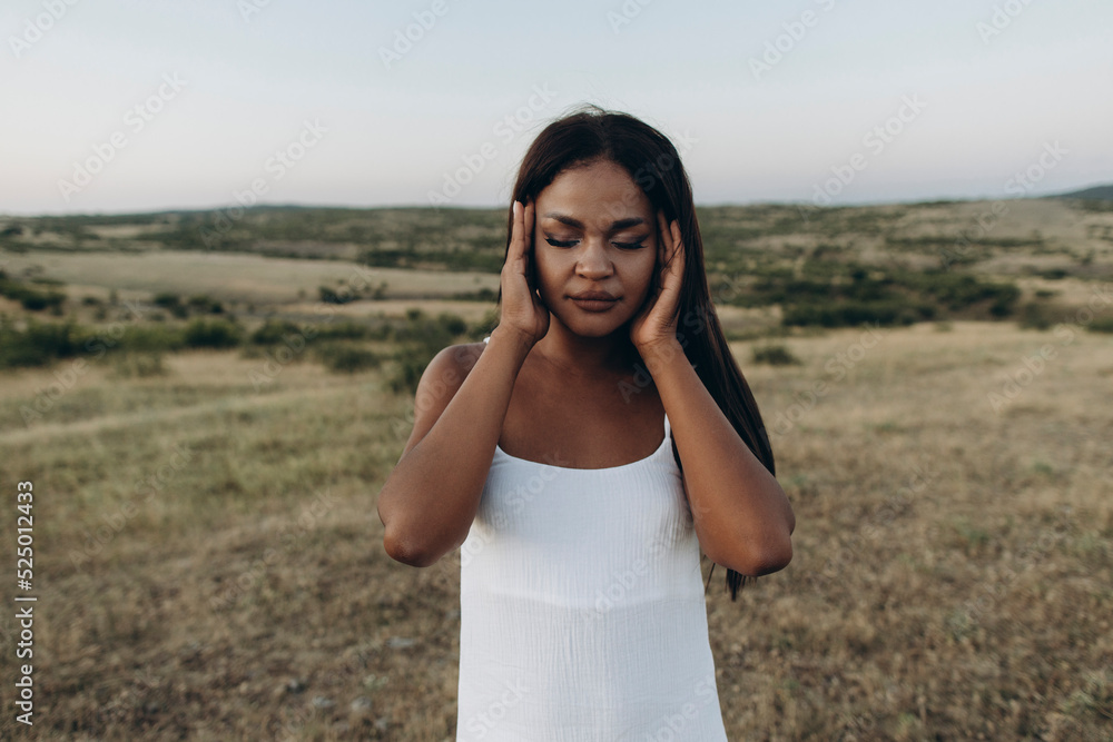 Woman with eyes closed rubbing head in meadow Woman with eyes closed rubbing head in meadow