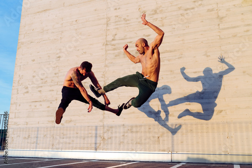 Young men practicing fly kick outdoors