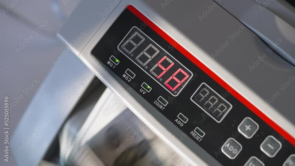 Numbers changing quickly on the panel of cash counting machine. Device at work, lamps are on. Close up. Numbers changing quickly on the panel of cash counting machine. Device at work, lamps are on. Close up.