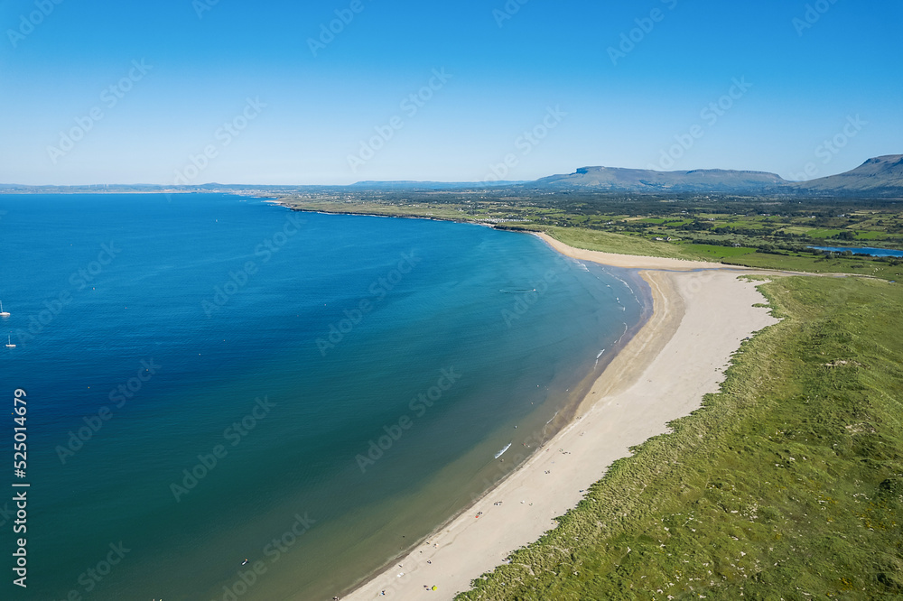 Stunning sandy beach and blue ocean and sky. Aerial view. Mullaghmore town area in county Sligo, Ireland, Popular travel destination with beautiful nature scenery and water sports. Warm sunny day.