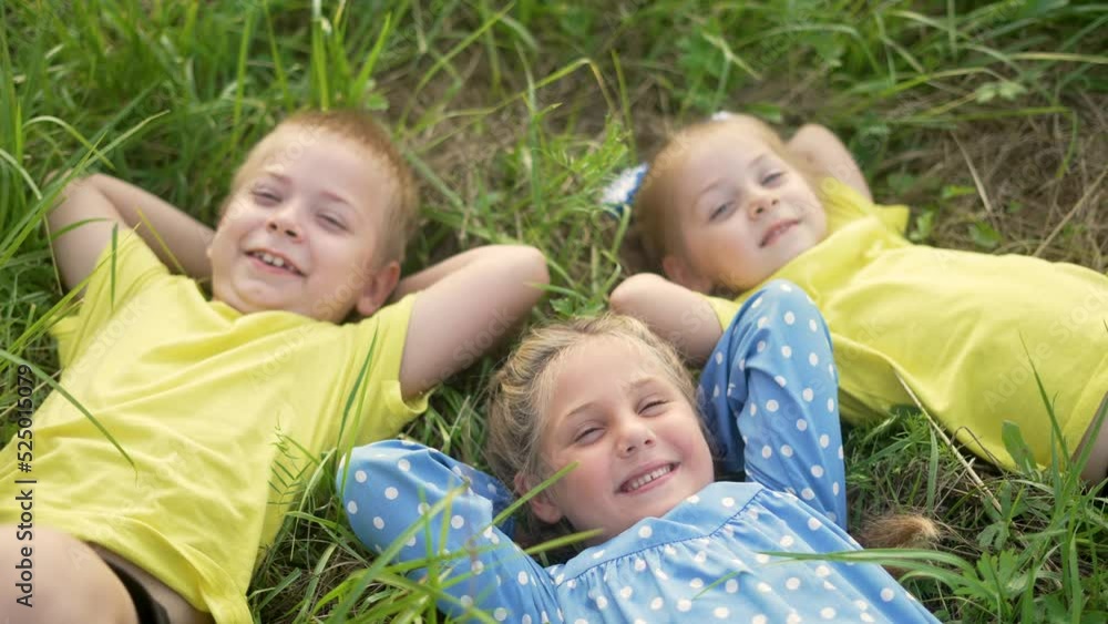 Happy child lie on green grass. Children friendship. Family is play in nature park. Happy smiles of child on green grass. Children friendship in nature park. Smiles child on grass. Family lie in park Happy child lie on green grass. Children friendship. Family is play in nature park. Happy smiles of child on green grass. Children friendship in nature park. Smiles child on grass. Family lie in park