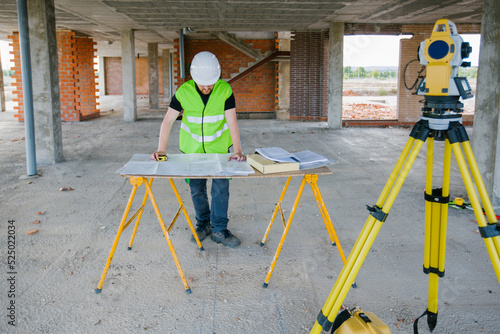 Surveyor engineer working at construction site with measuring eq photo